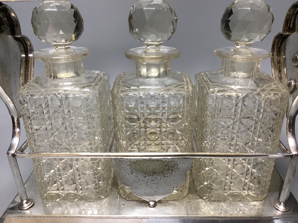 A late 19th / early 20th century silver plated three bottle tantalus, length 39cm